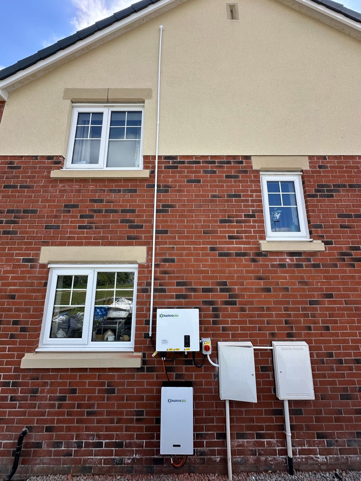 Domestic facade with wall-mounted EV charger and Powerwall